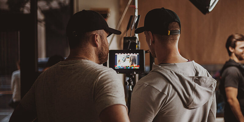 Digital-Imaging-Technician-DIT-Footage A digital imaging technician and a director of photography review footage on a small screen