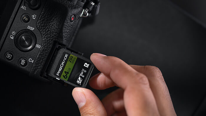 mac studio _ SD card Photographer inserting SD card into camera