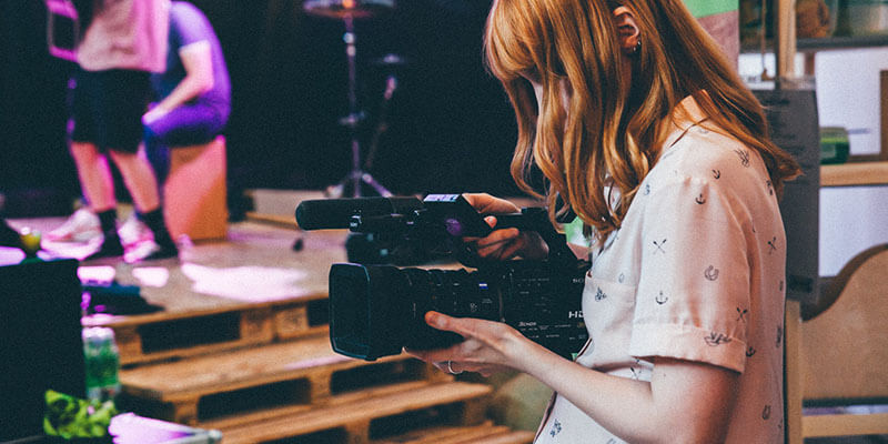 side-hustles-cinema-camera A woman uses a panasonic cinema camera she rented from a video production professional