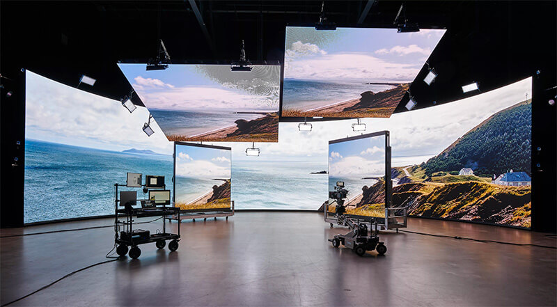 Virtual-production-behind-the-scenes A cliffside ocean view is displayed on a virtual production stage